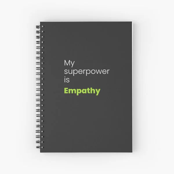 A spiral notebook with the phrase "My superpower is empathy" in white and green letters.