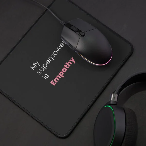 A mouse pad with the phrase "My superpower is empathy" in white and pink letters.