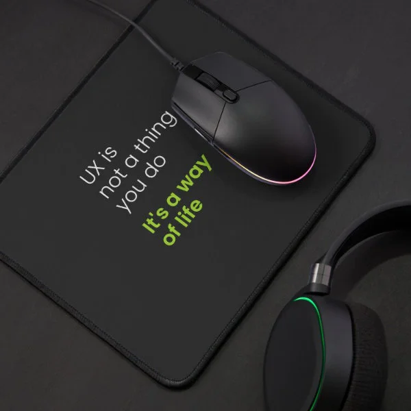 A mouse pad with the phrase "UX is not a thing you do, it&rsquo;s a way of life" in white and green letters.