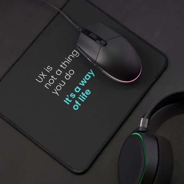 A mouse pad with the phrase "UX is not a thing you do, it&rsquo;s a way of life" in white and turquoise letters.